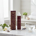 Aureq anti-age day cream bottle and box on a marble surface with decorative elements.
