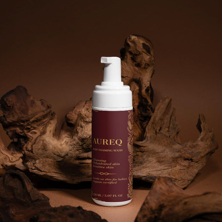 Foaming wash bottle with 'Aureq' branding on a brown background with wood elements.